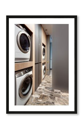 Modern washing machine in laundry room with white yellow black marble floor interior wooden natural tones ecological sustainability.