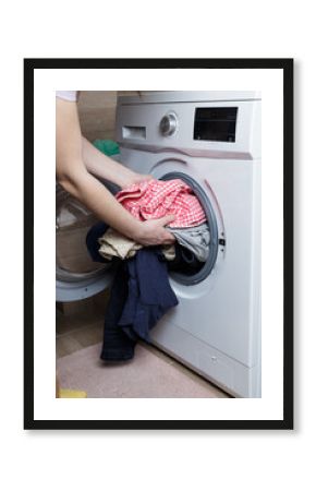 laundry washing concept. the girl is loading the washing machine.