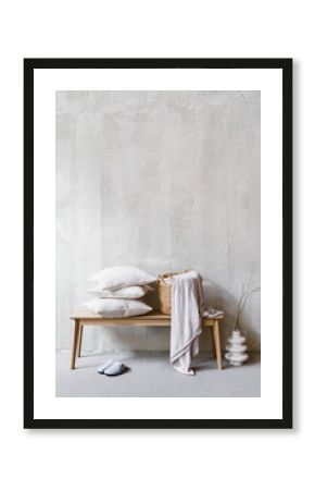 Pillows and wicker laundry basket with bedding on bench