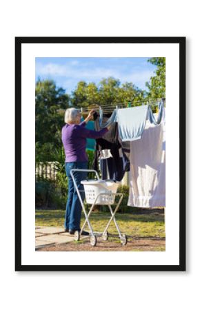 Elderly woman at clothes line with laundry trolley