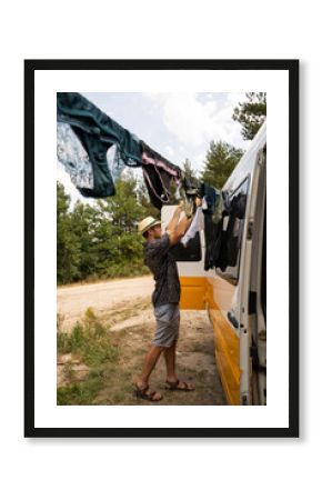 Man doing laundry by hand in camper van in nature