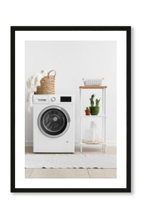 Interior of laundry room with washing machine, shelving unit and houseplants