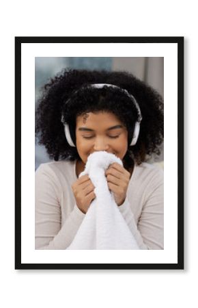 Cleaning, woman and smell laundry in home for hygiene, housekeeping and listening to music on headphones. Aroma, chores and happy for fresh fabric for wellness, washing and scent of textile cloth