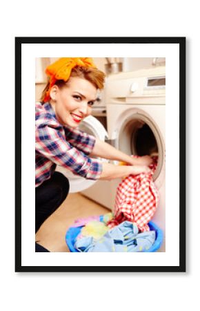 Housewife putting the laundry into the washing machine