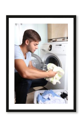 Housework: Man loading clothes into washing machine