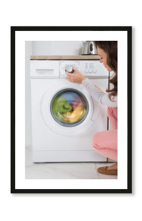 Woman Pressing Button Of Washing Machine