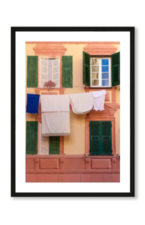 Shutters, fake windows and clothes hanging on a mediterranean fa