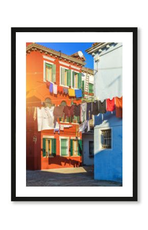 Laundry hanging out of typical houses of Burano Island, Venice, Italy. Multicolored buildings and laundry drying on the street in Burano, Venice, Italy