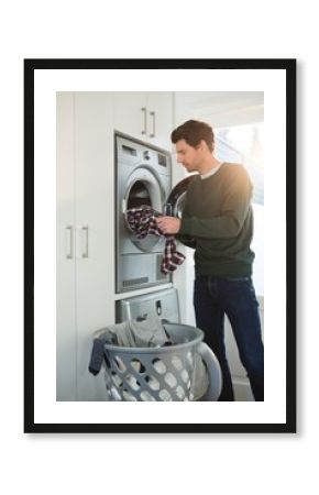 Man putting clothes in washing machine