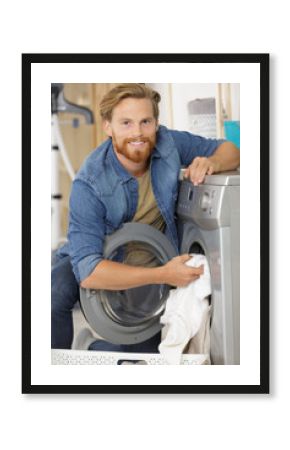 young man loading the laundry into the washing machine