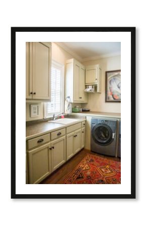 Large cream white laundry room with a window and natural light