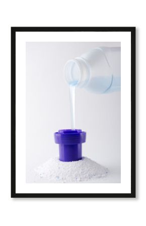Vertical image.Heap of laundry detergent and bottle of liquid one, white background