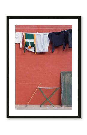 Clothes hanging on laundry line on wall.
