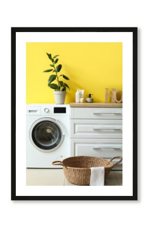 Interior of room with laundry basket, washing machine and counter