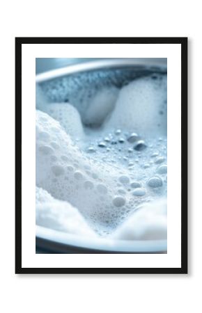 The washing machine drum shows white towels submerged in bubbly water as they soak during the laundry process. Generative AI