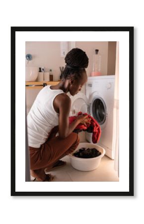 Black housekeeper doing laundry at home