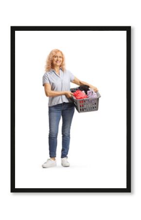 Full length portrait of a mature woman holding a laundry basket with clothes