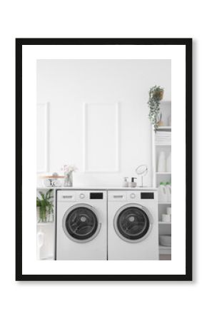 Interior of light laundry room with washing machines and shelving units