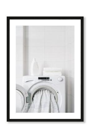 washer machine with dirty bedding in white bathroom