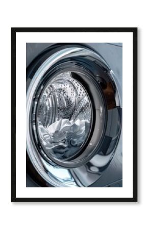 An intimate close-up of a washing machine's front, revealing the texture and colors of the laundry within