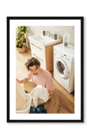 Young man busy in laundry room.