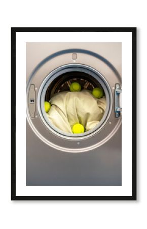 Balls and sheet inside washing machine at laundromat