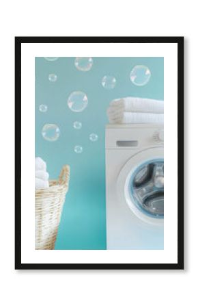 Washing machine on soft blue background, laundry basket on the side of the washing machine, soap bubbles flying in the background. Home laundry concept.