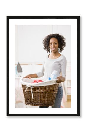 Housewife carrying laundry basket full of clothing