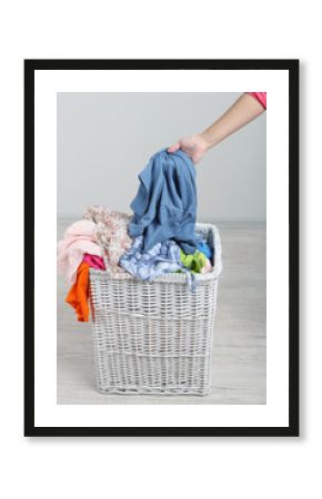 Woman with full laundry basket on gray background