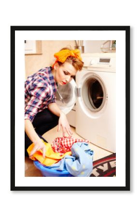 Housewife putting the laundry into the washing machine