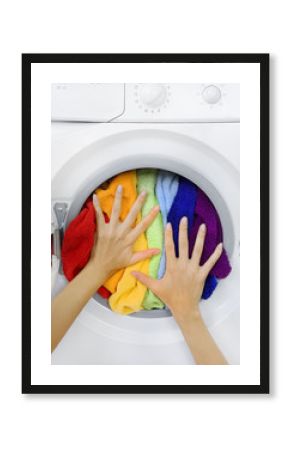 woman loading colorful laundry in the washing machine