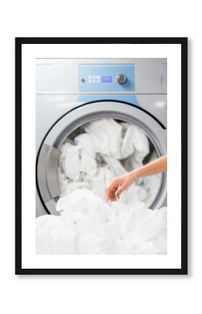 cropped view of maid near white bed sheets in laundry