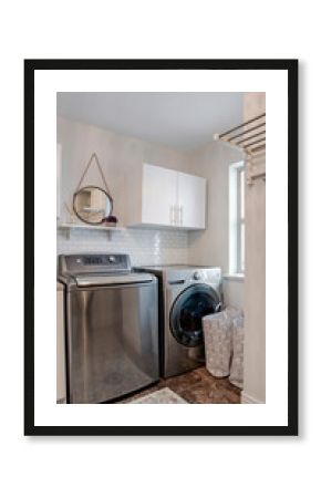 Vertical Laundry room interior with cabinets wahing machine and dryer against white wall