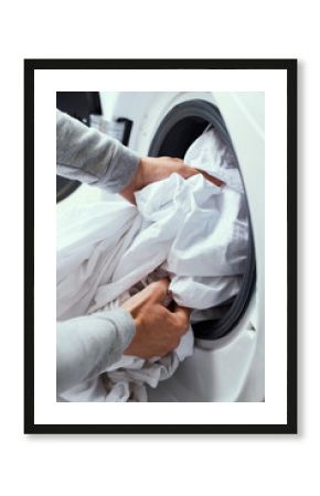 man putting clothes into the washing machine