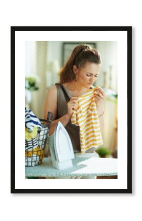 unhappy woman with iron, clothes basket unhappy with laundry