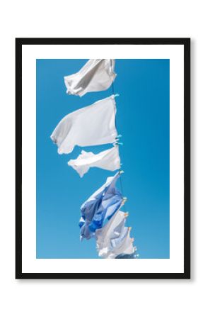 Hanging laundry against blue sky in movement by fresh wind