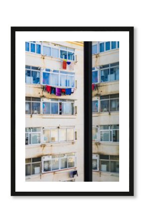 Colorful laundry hangs across buildings in a bustling neighborhood of Barcelona, Spain during a sunny day