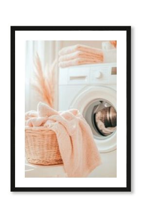 Laundry day with towels in a softly lit room featuring a washing machine and a basket of fresh laundry