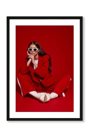 Fashion asian female model in red suit, white boots and sunglasses.