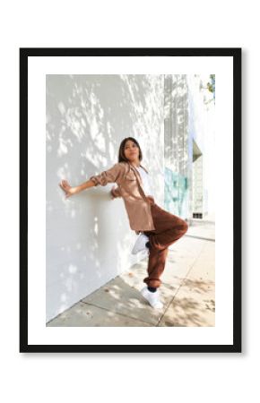 woman dancing hands touching white wall with plant shadows