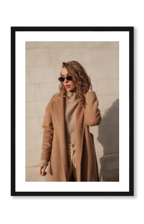 portrait of a style woman walking, enjoys a wonderful atmosphere of a vacation in fall time. The girl is wearing a urban beige sweater,  