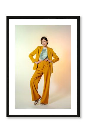 Brunette woman in yellow suit with hands on waist