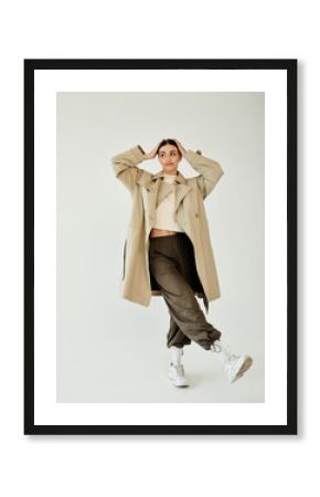 A young and beautiful woman poses confidently in a stylish autumn outfit, highlighting contemporary fashion trends.