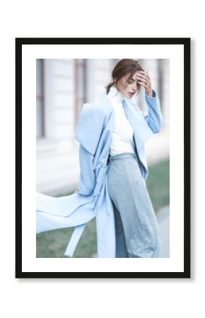 young beautiful stylish woman walking in street in blue coat, autumn fashion trend, smiling, happy.