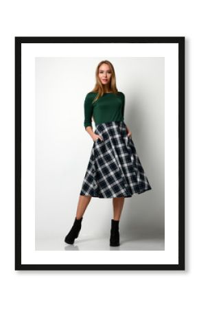 Young beautiful woman posing in new fashion plaid skirt and green blouse full body 