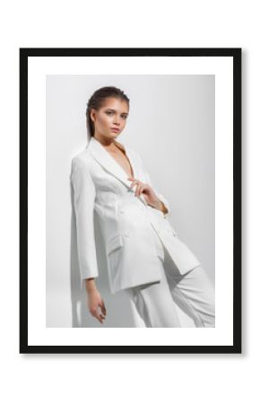 Young woman on a white wall background. High fashion