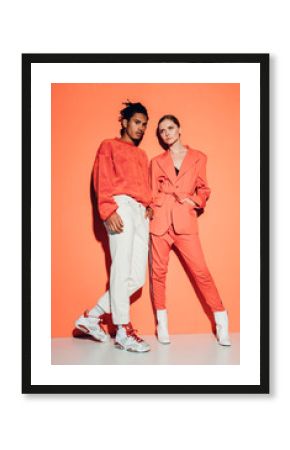 Casual couple in red leaning against a red wall