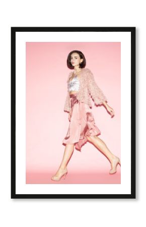 young fashion woman in pink clothes run on pink background, full lenght