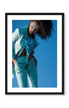 attractive african american woman holding bouquet isolated on blue