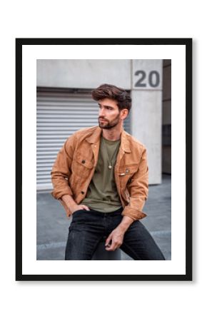 Handsome modern man sitting on the street in city, Male fashion model dressed casually.